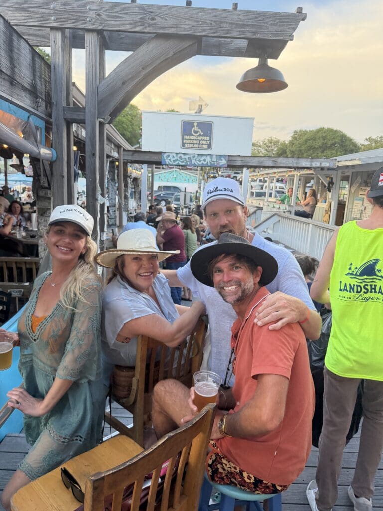 Friends smiling at outdoor bar with drinks