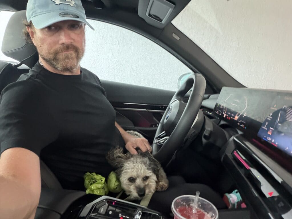 Man in car with small dog on lap